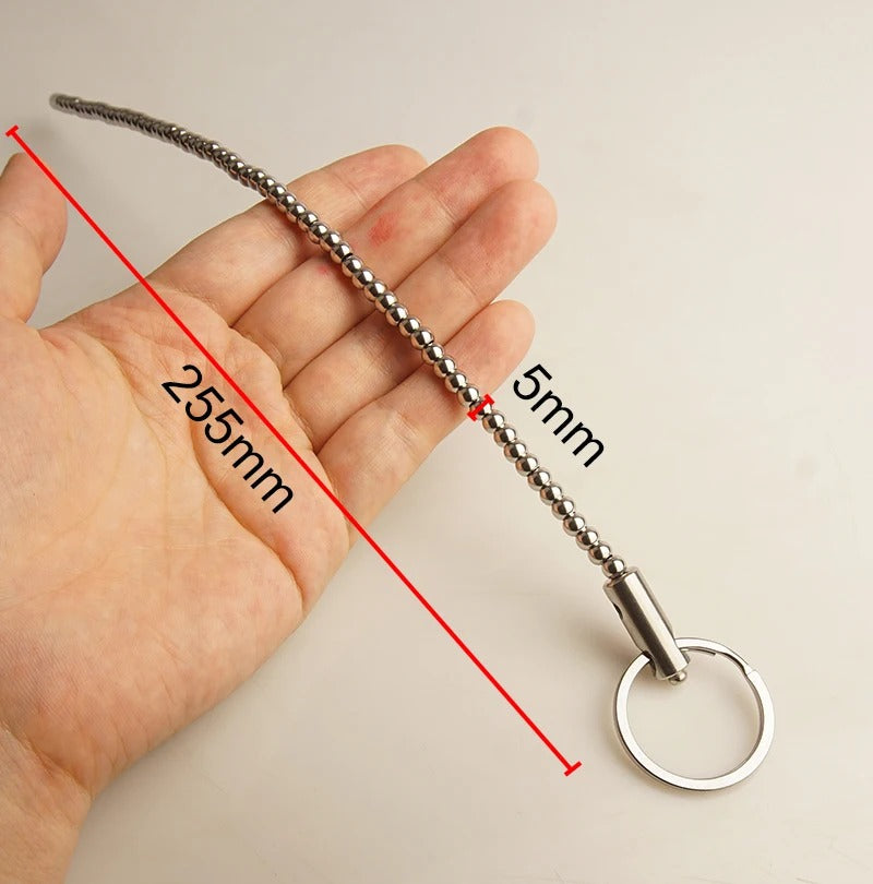 Polished stainless steel beaded urethral dilator for male urethral play, studio photo