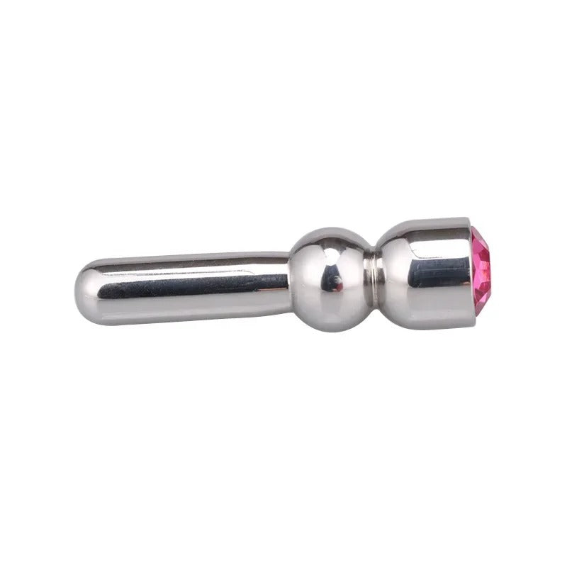 Close-up of red jewel-style cap on stainless steel urethral sound, polished metal housing detail