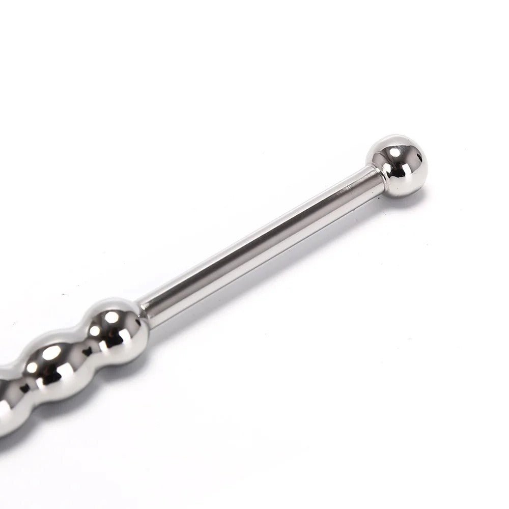 Detail shot of textured beaded shaft on long stainless steel urethral plug for varied internal stimulation