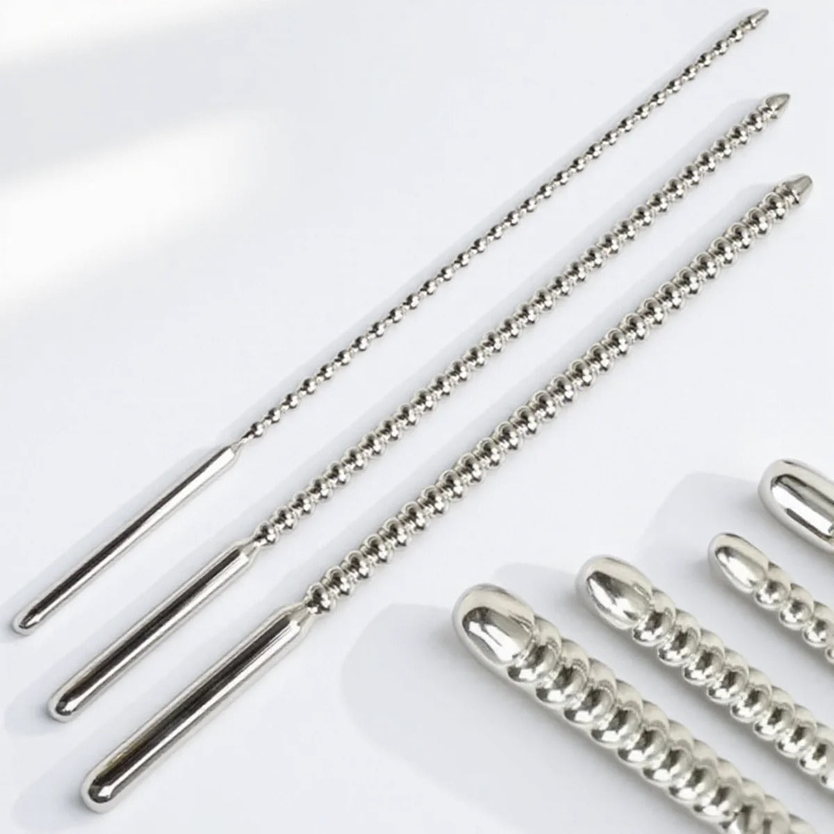 Male urethral stimulation dilator with beads in polished stainless steel, 3 sizes shown together on a clean background