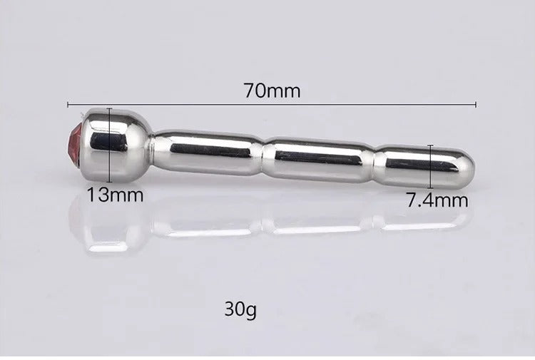 Angled studio shot of jeweled stainless steel urethral sound dilator jewelry, sleek mirror-polished finish