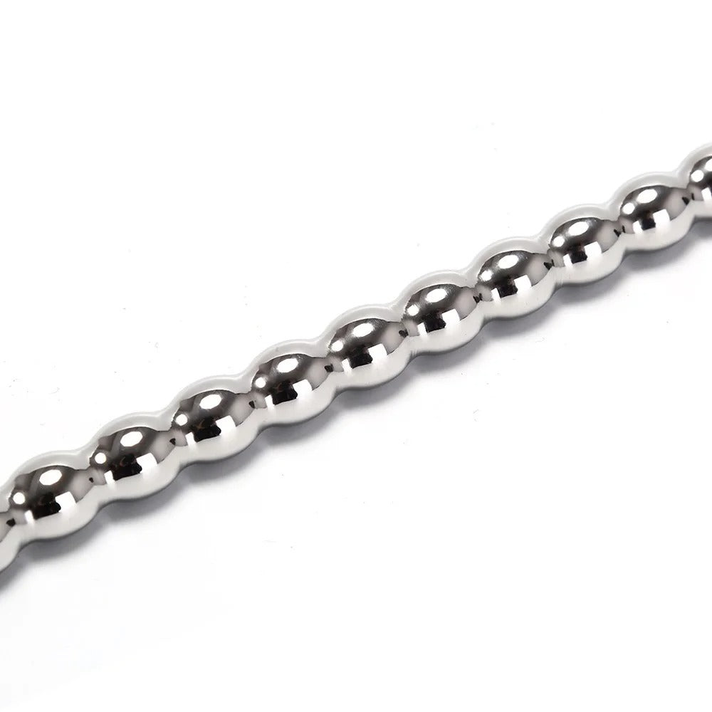 Studio angle view of long stainless steel urethral sounds set, polished finish and bead pattern visible